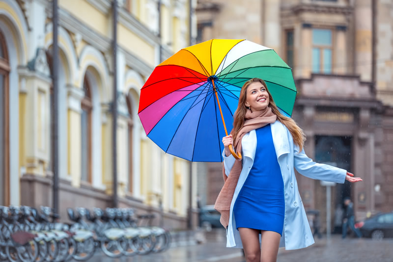 Rõõmus naine vihmavarjuga on valmis uut armastust leidma